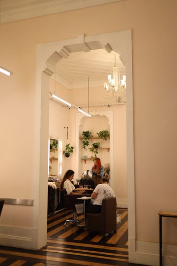 Hall do casarão do Constant Benjamin visto pelo arco, com lustre de cristal, piso de madeira e o salão ao fundo