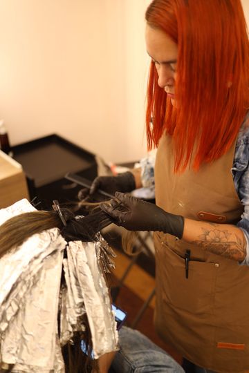 Profissional aplicando mechas com papel alumínio