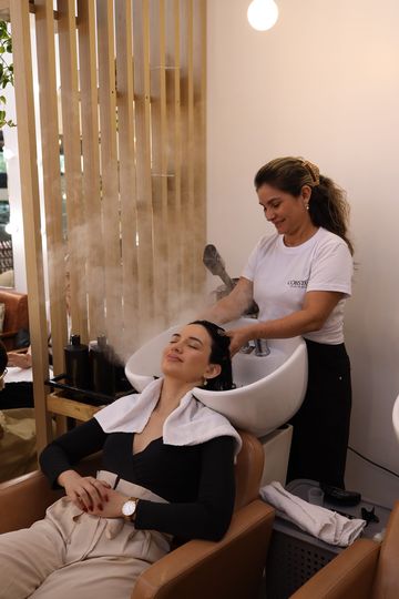 Cliente relaxada no lavatório, com vapor no cabelo