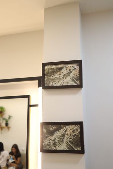 Dois quadros de paisagem em uma coluna branca entre espelhos no Constant Plaza